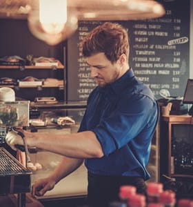 Een jobstudent of flexi-jobber werkt in een café naast zijn lesuren.