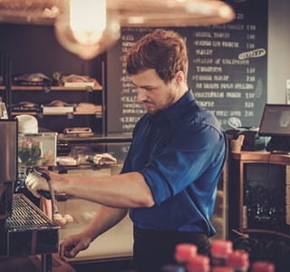 Een jobstudent of flexi-jobber werkt in een café naast zijn lesuren.