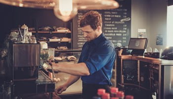 Un étudiant ou un flexi-jobiste travaille dans un café en dehors de ses heures de cours.