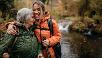 Une femme plus âgée se promène avec sa petite-fille majeure à qui elle a fait une donation par virement bancaire et assurance-vie.