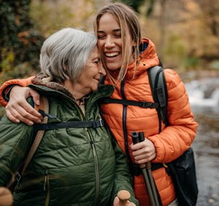 Une femme plus âgée se promène avec sa petite-fille majeure à qui elle a fait une donation par virement bancaire et assurance-vie.