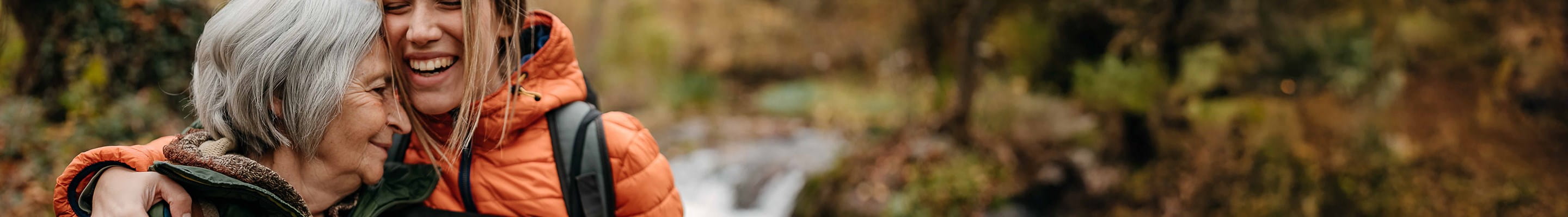 Une femme plus âgée se promène avec sa petite-fille majeure à qui elle a fait une donation par virement bancaire et assurance-vie.