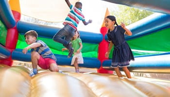 Kinderen spelen op een springkasteel nadat u als organisatie de nodige preventieve maatregelen hebt genomen in het kader van uw aansprakelijkheid.