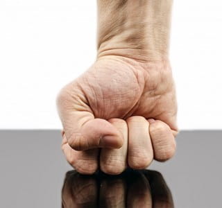 Vuist die agressie op het werk weerspiegelt