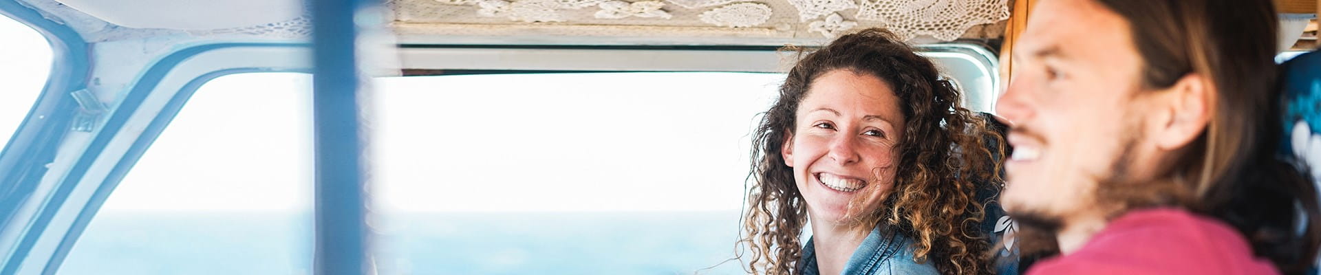 Jong koppel is blij terwijl ze hun tiny house vervoeren.