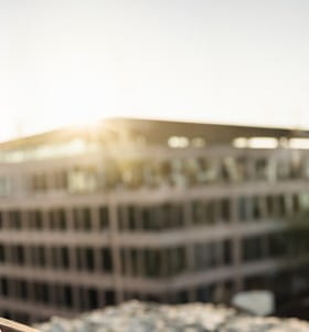 Une dame âgée bénéficie de sa pension complémentaire et regarde les appartements depuis son balcon.