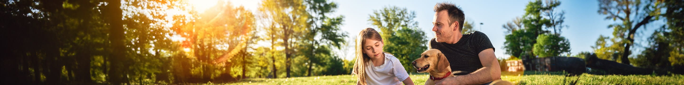 Een gezin geniet van de zon in het park: bij schade aan derden kunnen ze de schadeaangifte voor hun familiale verzekering makkelijk melden en opvolgen.