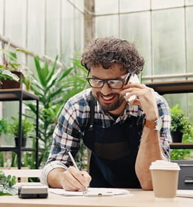 Freelance qui se renseigne au téléphone sur les possibilités d’assurances professionnelles.