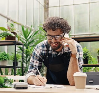 Freelance qui se renseigne au téléphone sur les possibilités d’assurances professionnelles.