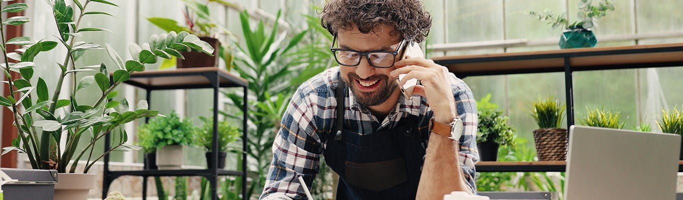 Freelance qui se renseigne au téléphone sur les possibilités d’assurances professionnelles.