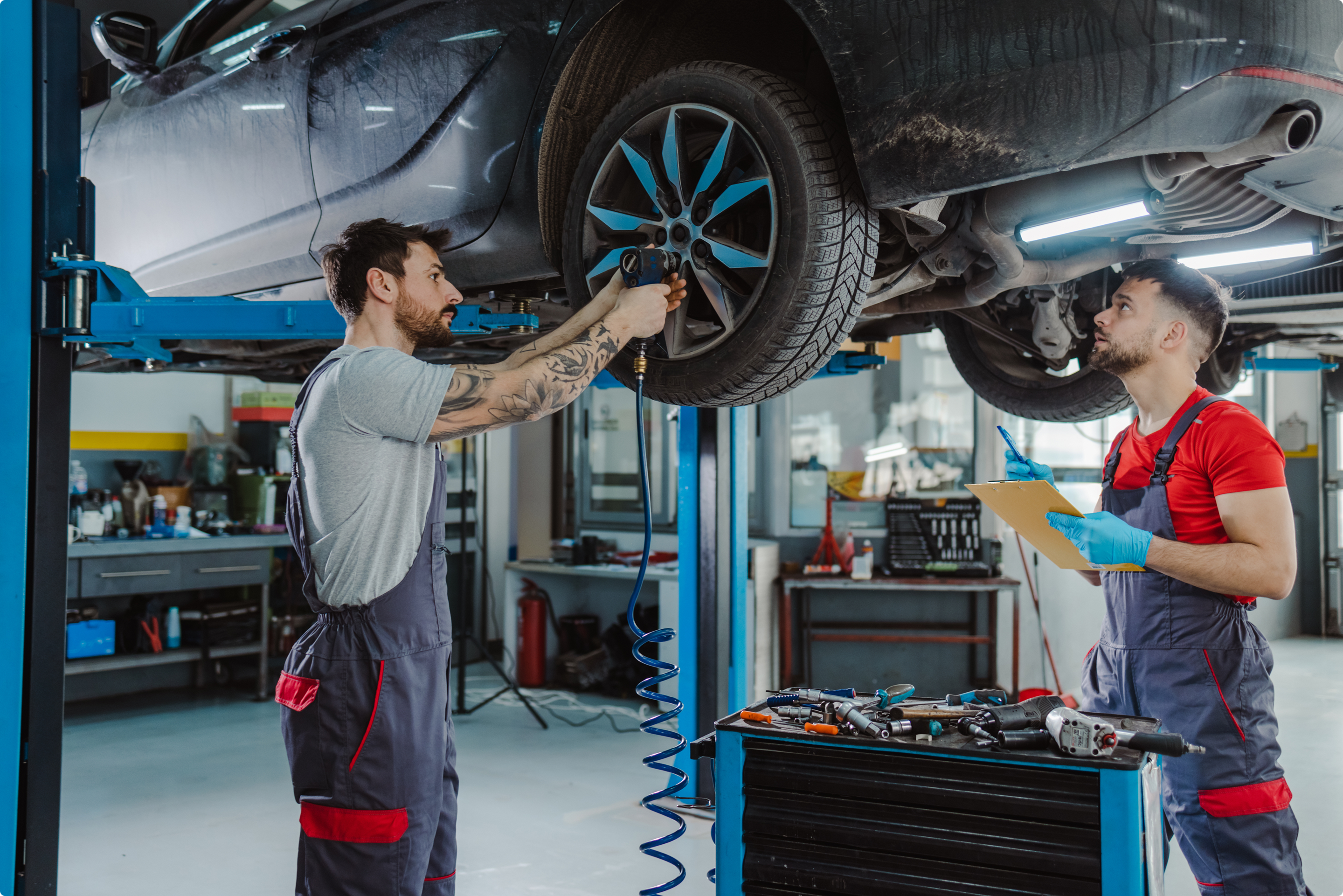 Twee garagisten voeren een snelle autoherstelling uit via de service Fast Car Repair van AXA. 