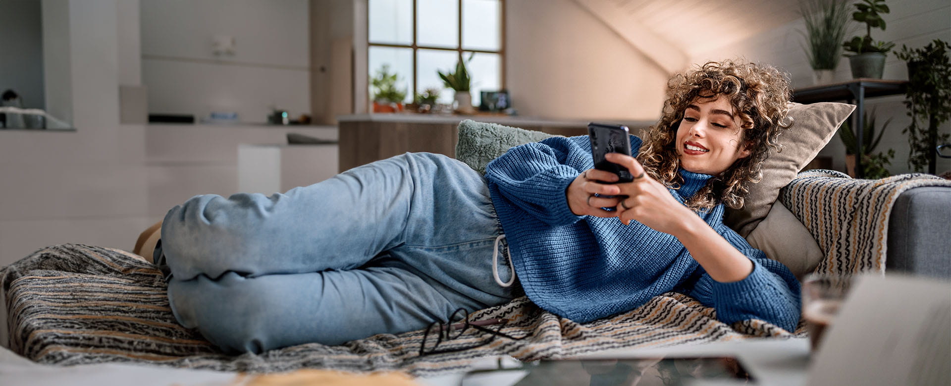Vrouw sluit thuis een brandverzekering af op haar smartphone.