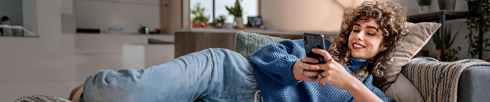Vrouw sluit thuis een brandverzekering af op haar smartphone.