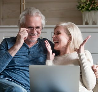 Un couple se renseigne sur le bonus de pension sur leur ordinateur portable