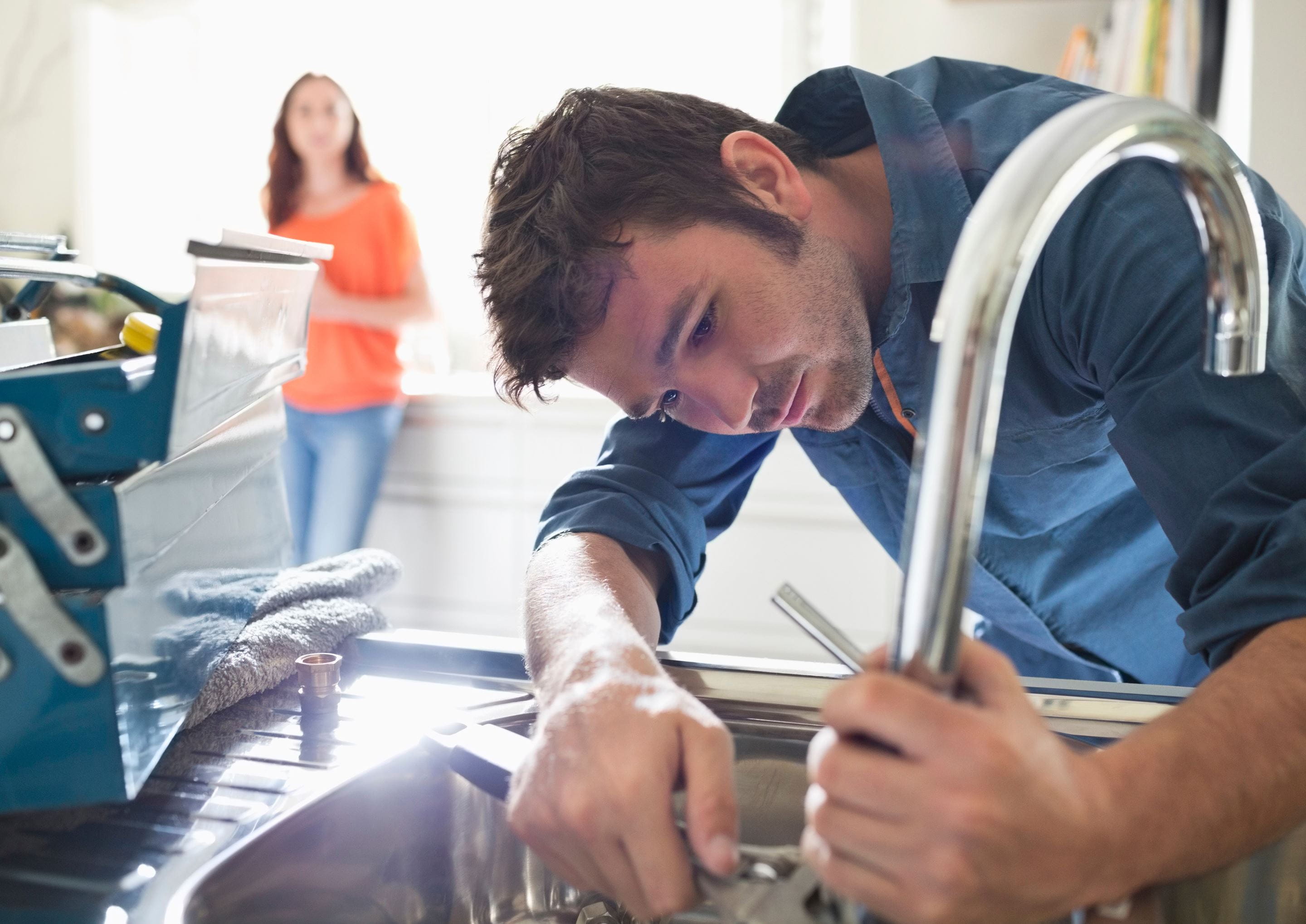 Un plombier réalise une réparation en nature rapide.