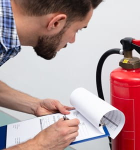 Man checkt brandblusser voor een optimale brandpreventie.