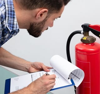 Man checkt brandblusser voor een optimale brandpreventie.