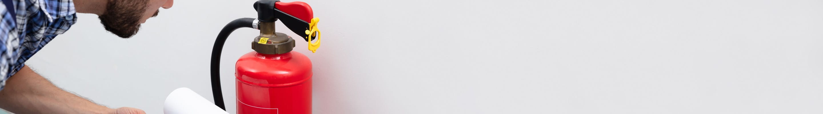 Man checkt brandblusser voor een optimale brandpreventie.