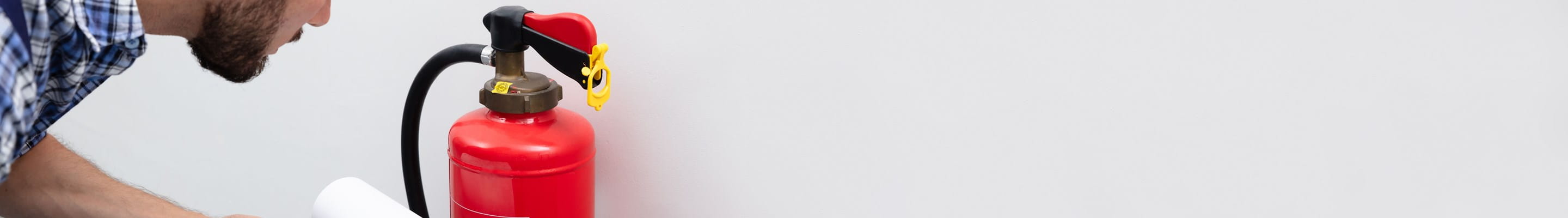 Homme qui vérifie son exctincteur pour une prévention des incendies optimale.