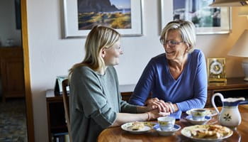 mère d’une cinquantaine d’année discute de son épargne à long terme et la déduction fiscale en dînant avec sa fille.