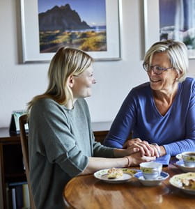 mère d’une cinquantaine d’année discute de son épargne à long terme et la déduction fiscale en dînant avec sa fille.
