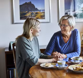 mère d’une cinquantaine d’année discute de son épargne à long terme et la déduction fiscale en dînant avec sa fille.