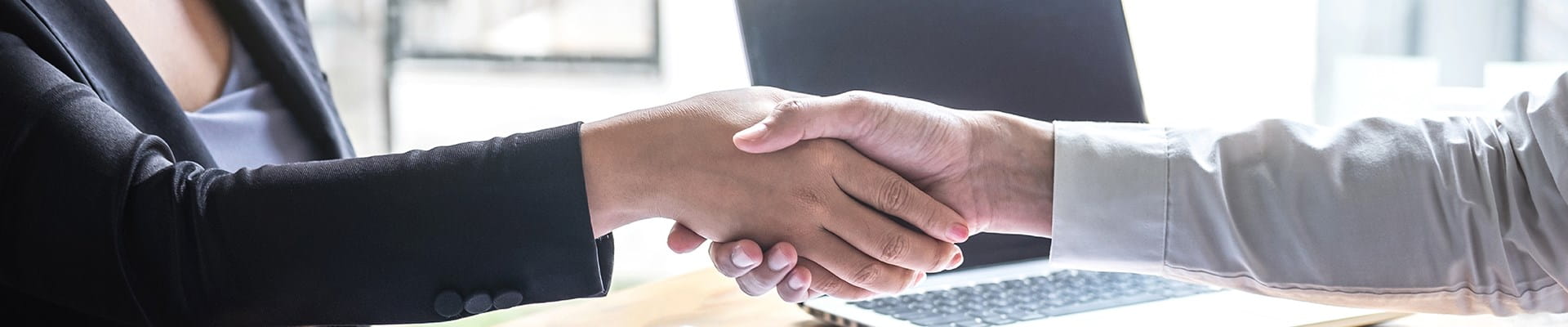 Medewerker van AXA die een klant uit de publieke sector begroet.