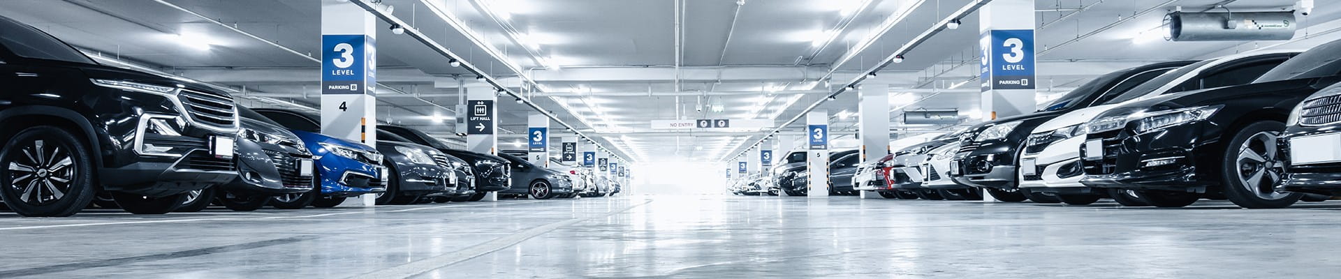 Garage d'entreprise rempli de voitures de la flotte de l'entreprise, qui sont toutes couvertes par une assurance mobilité d'AXA.