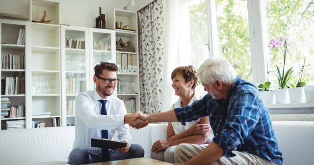 Een expert beoordeelt samen met een koppel de schade aan hun woning.