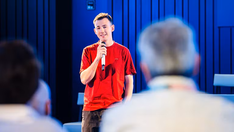 Loïc Van Impe s’exprime devant des collaborateurs d’AXA dans les bureaux d’AXA, au micro, sur l’entrepreneuriat et les risques dans l’horeca.