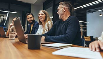 Gelukkige werkneemster tijdens een vergadering met haar behulpzame collega’s.