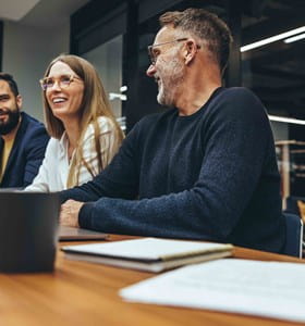 Gelukkige werkneemster tijdens een vergadering met haar behulpzame collega’s.