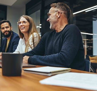 Gelukkige werkneemster tijdens een vergadering met haar behulpzame collega’s.